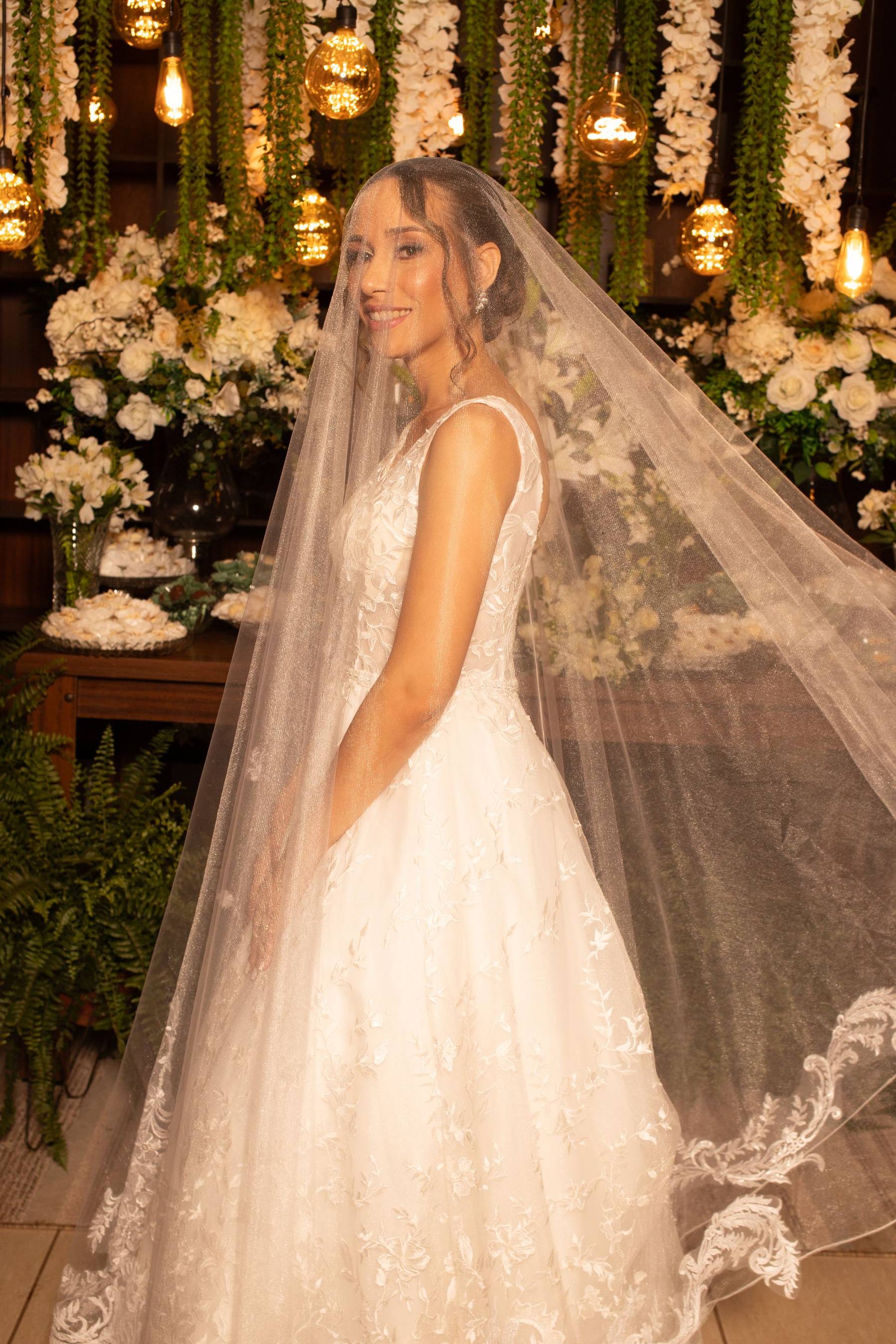 Bride standing before a floral ceremony backdrop